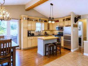 a kitchen with wooden cabinets and a island with bar stools at Chalet Rouge in Ruidoso