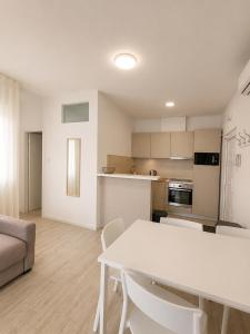 a living room with a white table and a kitchen at Aparthouse Penelope in Supetarska Draga