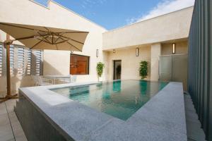 a swimming pool in a house with an umbrella at Hotel Ieum Mokpo peace square branch in Mokpo