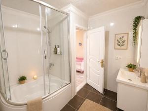 a white bathroom with a shower and a sink at Villa Incir in Kuşadası