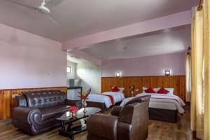 a hotel room with two beds and a couch at Hotel Monalisa Chitwan in Sauraha