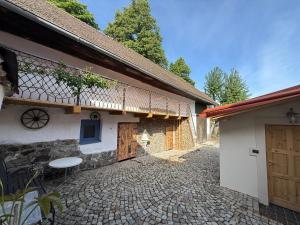 an external view of a house with a stone courtyard at Chalupy Albrechtice A,B,C Šumava in Sušice