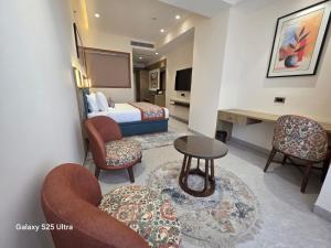 a hotel room with a bed and chairs and a table at Avio Hotel in Chandigarh Airport