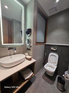 a bathroom with a sink and a toilet and a mirror at Avio Hotel in Chandigarh Airport