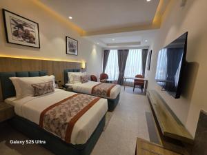 a hotel room with two beds and a flat screen tv at Avio Hotel in Chandigarh Airport +14 photos