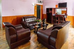 a living room with leather furniture and a table at Hotel Monalisa Chitwan in Chitwan