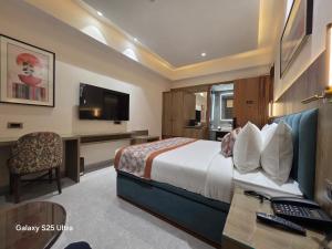 a hotel room with a bed and a desk with a computer at Avio Hotel in Chandigarh Airport