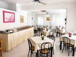 a restaurant with tables and chairs and a buffet at Hotel Malibù in Rimini