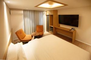 a hotel room with a bed and a flat screen tv at Hotel Ieum Mokpo peace square branch in Mokpo