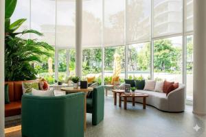 a living room with green furniture and large windows at Phyll Condo Room in Wichit in Ban Rangeng