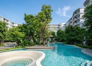 a swimming pool in front of a building at Phyll Condo Room in Wichit in Ban Rangeng
