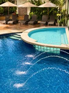 a large swimming pool with chairs and umbrellas at Red Coco Inn de Boracay in Boracay