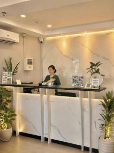 a woman sitting at a counter in an office at Red Coco Inn de Boracay in Boracay +46 photos