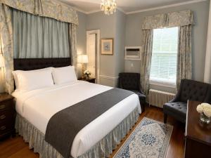 a bedroom with a bed and a chair and a window at Bellevue Manor in Newport +29 photos