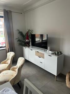 a living room with a television and two chairs at Mysig lägenhet Malmö Centralt in Malmö