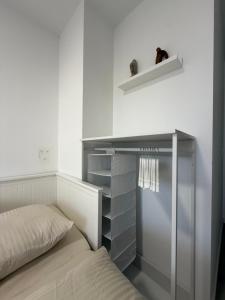 a bed in a room with a shelf and a bed sidx sidx sidx at Une petite chambre jardin in Dijon