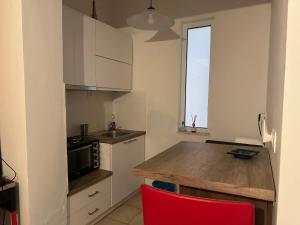 a kitchen with a wooden counter top and a red chair at The salty studio in Rethymno