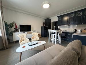 a living room with a couch and a table and a kitchen at Mysig lägenhet Malmö Centralt in Malmö