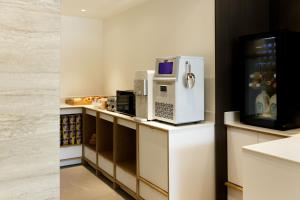 a kitchen with a microwave and a refrigerator on a counter at Hotel Ieum Mokpo peace square branch in Mokpo