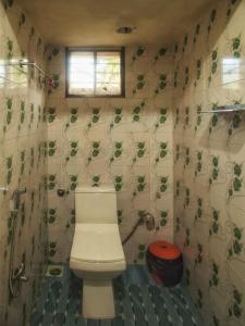 a small bathroom with a toilet and a window at PONMUDI DALE. HOMESTAY in Kallar-Bridge
