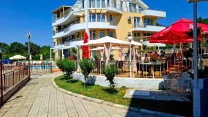 a building with tables and umbrellas in front of it at Peaceful Retreat at Sunset Resort Complex, Kosharitsa in Kosharitsa