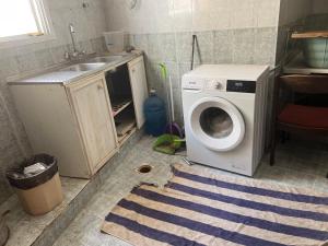 a laundry room with a sink and a washing machine at Turkish Muscat hostel in Muscat