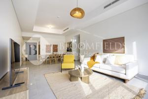 a living room with a white couch and a yellow chair at Bloomfields 2BR in Lamar Raha Beach in Abu Dhabi