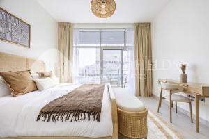 a bedroom with a bed and a desk and a window at Bloomfields 2BR in Lamar Raha Beach in Abu Dhabi