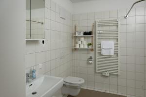 a white bathroom with a toilet and a sink at Zirbitzblick in Mönchegg