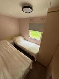 a small room with two beds and a window at The Sea Spot in Zvejniekciems