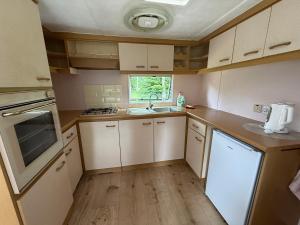 a small kitchen with white cabinets and a sink at The Sea Spot in Zvejniekciems