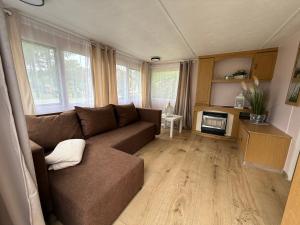 a living room with a brown couch and a table at The Sea Spot in Zvejniekciems