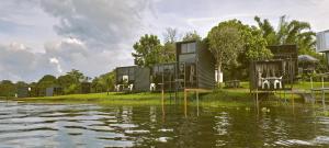 a group of modular houses on the side of a river at FREESCAPE Quiet Reset - Lakeside Mountainview in Cavinti