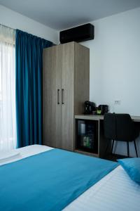 a bedroom with a bed and a cabinet with a tv at Wezen in Vama Veche