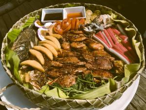 a platter of food with meat and vegetables on a table at FREESCAPE Quiet Reset - Lakeside Mountainview in Cavinti