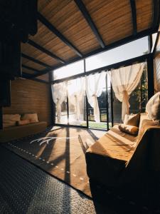 a bedroom with a bed and a large window at FREESCAPE Quiet Reset - Lakeside Mountainview in Cavinti