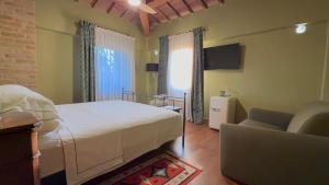 ein Schlafzimmer mit einem Bett, einer Couch und einem Fernseher in der Unterkunft Sacro e Profano Albania in Zikxhafaj