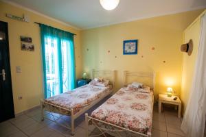two beds in a room with a window at Villa Ladina in Lygia