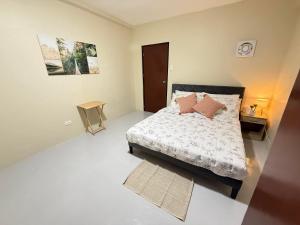 a bedroom with a bed with pink pillows on it at Thousand Journey 2 in Naga