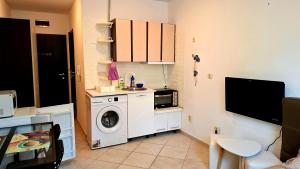 a kitchen with a washing machine and a microwave at Peaceful Retreat at Sunset Resort Complex, Kosharitsa in Kosharitsa