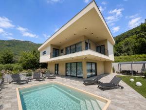 a house with a swimming pool in front of it at Villa Perla di Draga in Mošćenička Draga
