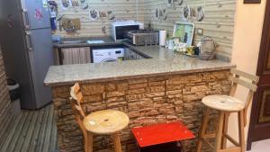 a kitchen with a counter with two chairs and a refrigerator at Ras elbar Palace in Ras El Bar