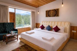 a bedroom with a bed and a chair and a window at Hotel Old Manali with Balcony, Mountain and River View in Manāli