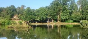 a view of a lake with a house in the background at Summers Breeze in Nantheuil
