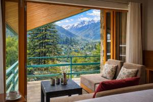a room with a bed and a view of a mountain at Hotel Old Manali with Balcony, Mountain and River View in Manāli