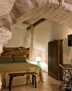 a bedroom with a bed in a stone wall at Trullo Galileo in Alberobello