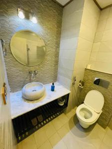 a bathroom with a toilet and a sink with a mirror at Three Trees Hotel Islamabad in Islamabad