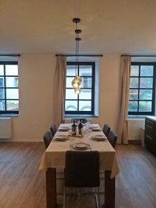 a dining room with a table with chairs and a chandelier at Hébergement atypique in Esch-sur-Sûre