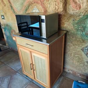 a microwave on top of a cabinet with a table at Casa Gaudi - House & Rooms in Teulada