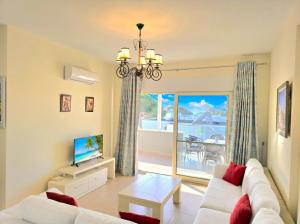 a living room with a white couch and a television at Sunny Beach Penthouse 271 in Lalzit Bay